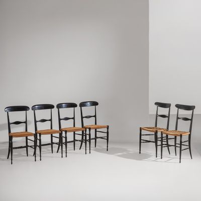 quatre chaises dans une pièce aux murs et au sol blancs