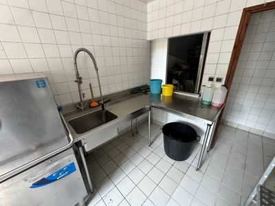 une cuisine équipée d'un évier et d'un lave-linge