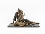 statue of a woman sitting on a rock with a cigarette in her hand