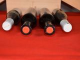 several bottles of wine are lined up on a red table