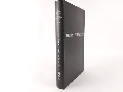 a black book sitting on top of a white table next to a white wall