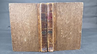 two old books sitting on top of each other on a table