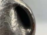 un vase en argent percé d'un trou au milieu