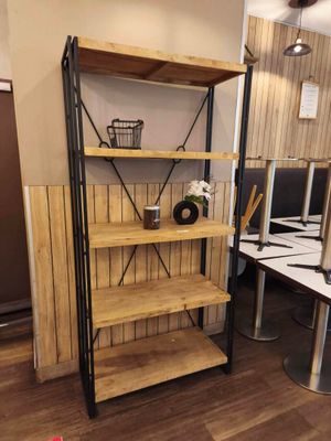 a wooden shelf with a basket on it in the corner of a room