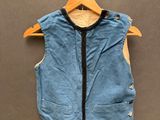 un gilet bleu accroché à un cintre sur un mur