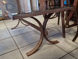 une table en verre avec une base en bois et un plateau en verre
