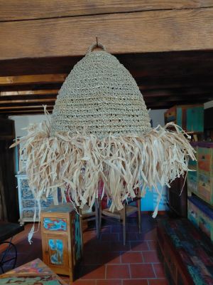 a large straw hat hanging from the ceiling in a living room