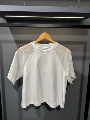 un t-shirt blanc suspendu à un cintre dans une armoire