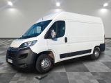 la camionnette blanche est garée sur un sol carrelé en damier