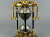 an image of a gold and black hourglass with a dragon on top