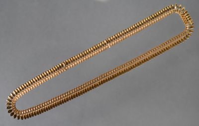 une chaîne en or tenue par une main