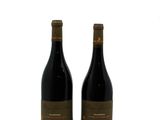 two bottles of wine sitting next to each other on a white surface