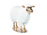une statue de mouton blanche et dorée posée sur une surface blanche