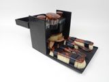 une boîte noire contenant des pinceaux et un flacon de liquide