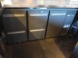 stainless steel counter top with three refrigerators and a trash can