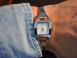 a person wearing a silver watch on their wrist