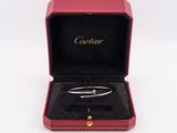 an open box with a silver bracelet inside of it on a white surface