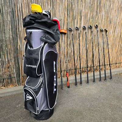 a bag of golf clubs sitting next to a row of poles