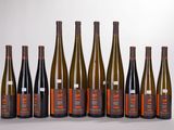six bottles of wine are lined up in a row on a white surface