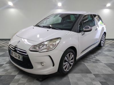 la petite voiture blanche est garée sur un sol en damier