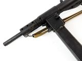 a close up of a machine gun laying on top of a white surface