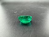 a close up of a green emerald stone on a black surface