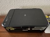 the canon printer is sitting on top of a wooden table