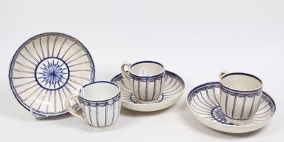 quatre tasses et soucoupes posées sur une table blanche