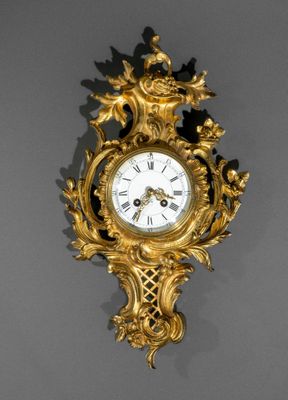une horloge dorée accrochée au mur sur fond noir