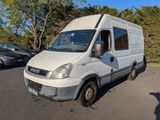 une camionnette blanche garée sur un parking avec des arbres en arrière-plan