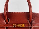 a brown leather handbag on a white background