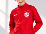 boy in a red jacket and black pants posing for a picture