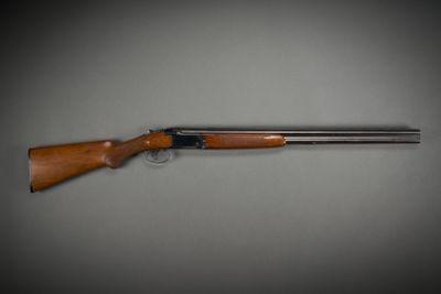 a shotgun with a wooden handle on a gray background