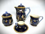 a blue and gold tea set on a white table