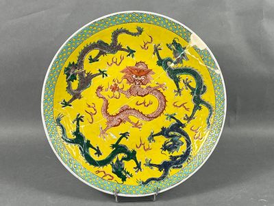 assiette jaune et verte ornée de motifs de dragons, posée sur un socle