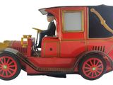 une petite voiture rouge avec un homme assis au volant