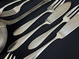 a lot of silver spoons and forks on a table