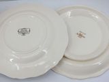two white plates with brown designs on them sitting on a table