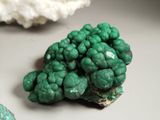 a cluster of green rocks on a table next to some rocks