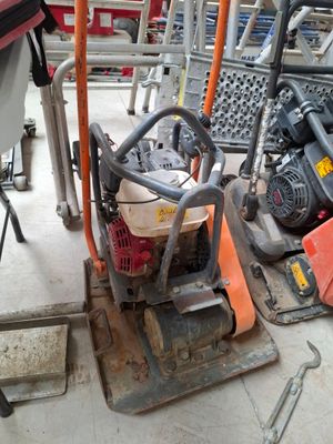 une petite machine posée par terre à côté d'un tas d'outils