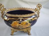 a blue and gold vase sitting on a stand