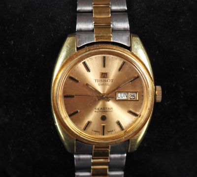 an image of a gold and silver watch on a black surface