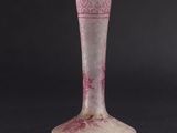 a pink glass vase sitting on a black surface