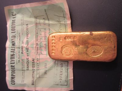 un lingot d'or posé sur une feuille de papier