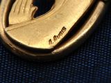 a gold medal with a praying woman on it