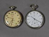 deux montres de poche posées côte à côte sur une table
