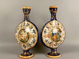 pair of blue and gold vases with a picture of a man and a woman on them