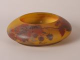 un vase jaune orné d'un motif floral rouge