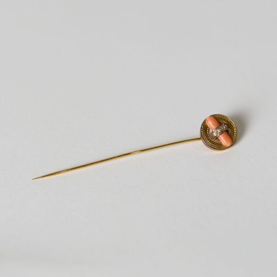 une image représentant une broche aux couleurs or et corail