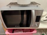 a microwave that is sitting on top of a trash can